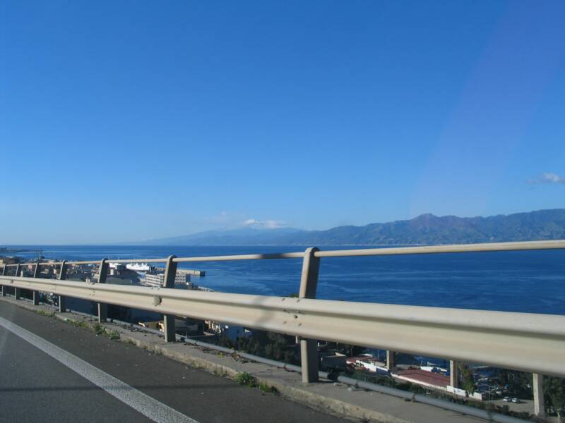 driving along the A3 highway towards the RC airport with Sicily and snow covered mnt Etna in the background